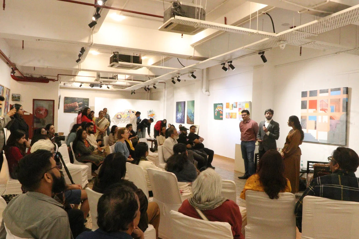 Visitors looking at original paintings at Within the Canvas